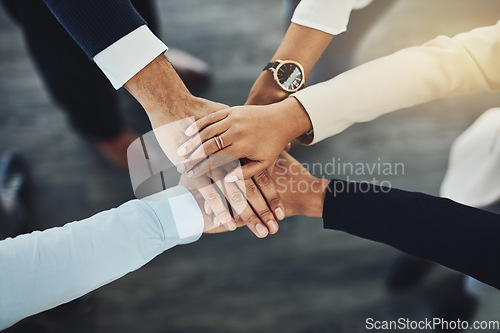 Image of Hands stacked or piled to show team unity, strength or motivation among business men, women or colleagues from above. Closeup of huddled, motivated group of businesspeople in support and trust circle