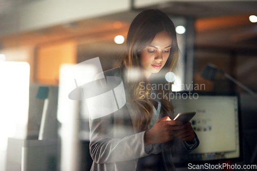 Image of Business woman reading message on phone, checking notifications and browsing online for a cab after working late in dark office. Corporate professional, employee and worker scrolling on social media