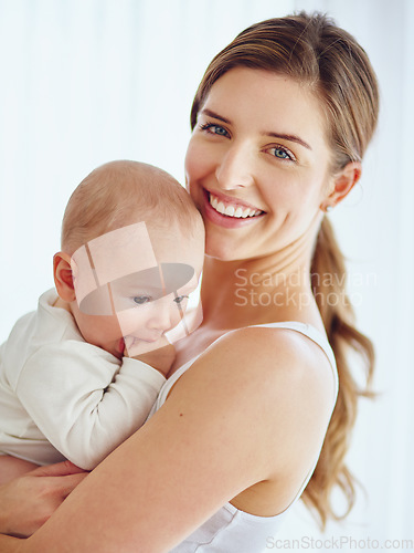 Image of Mother bonding with baby boy, smiling and enjoying family time in a room at home. Portrait of a happy, loving and caring single parent holding or carrying an adorable, cute and little newborn child