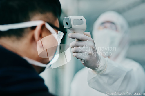 Image of Travel, healthcare and covid temperature testing outside with an infrared thermometer. Medical professional doing a coronavirus check on a man at airport entrance to prevent the spread of the virus