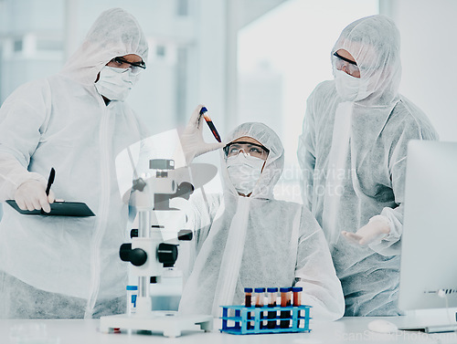 Image of Group of doctors and scientists conducting medical research on viruses dressed in hazmat suits, for coronavirus cure in the lab. Researchers conducting experiments and examining test tube