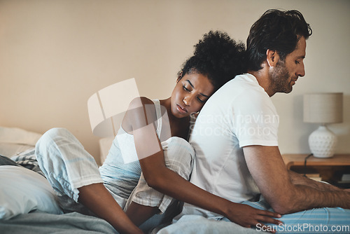 Image of Woman tries to embrace her husband with affection after their fight at home. Unhappy interracial couple with marriage problems forgive each other. Empathy and guilty feelings after the affair.