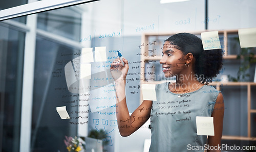 Image of Female leadership and marketing professional brainstorming innovation ideas, writing on transparent board with sticky notes in office. Young entrepreneur planning business mission and strategy.