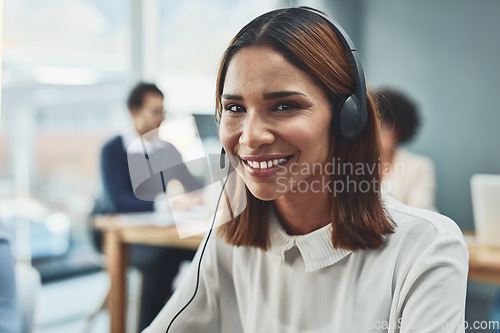 Image of Customer service, IT support or call center agent helping and assisting on a call using a headset. Portrait of a young female sales assistant or secretary smiling while working in a modern office