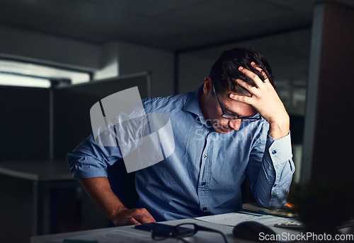 Image of Stressed, tired business man suffering from headache, working late night in the office. Worried male entrepreneur thinking about problems and project deadline feeling burnout, distress and exhausted.