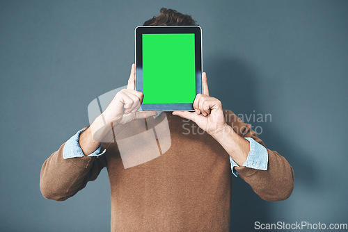 Image of Tablet with green screen, chroma key and copy space held by man against grey background. Technology and advertising or marketing of a digital business at a workplace. Creativity online and innovation