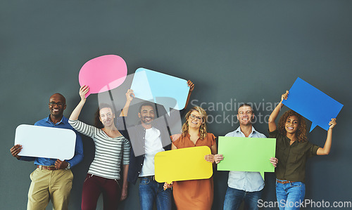 Image of Smiling casual team of diverse people holding opinion speech bubbles, to voice their important communication message. Creative group standing with colorful copyspace sign boards together in a row