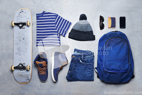 Image of Skater boy outfit, style or fashion laid out on the floor looking edgy, trendy and fashionable with a skateboard top view. Cool, stylish and casual monochrome skateboarding clothes, equipment or gear
