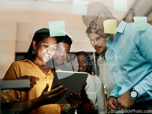 Image of Group of creative, excited and smiling design team, working, researching and browsing on tablet for innovation ideas in modern office. Office workers planning a group work project after hours.