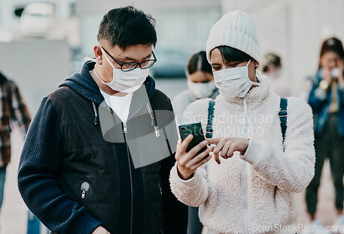 Image of People in covid face mask and phone searching information online looking at the news on travel ban restriction on social media while stranded at the border. Modern foreign traveling people at airport