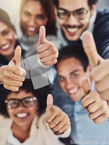 Image of Thumbs up from a happy business team excited about the success they achieve together at work. Overhead view diverse group of corporate people excited by success and give approval to winning