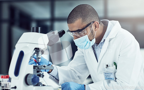 Image of Serious young male scientist working on scientific cure for covid in a lab. Professional man in science at work during pandemic on a medical mission, thinking and vision for a vaccine for the virus.