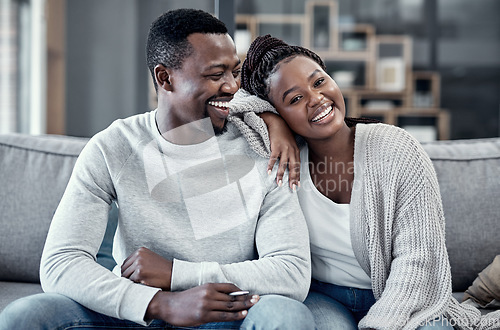 Image of Happy, in love, and carefree couple relaxing, smiling and laughing together at home portrait while enjoying their weekend spent indoors. Young African wife and loving husband bonding on their couch