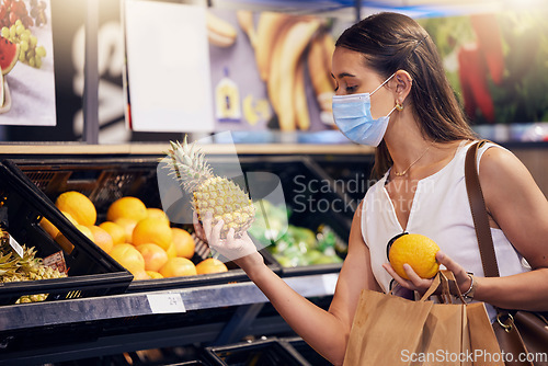 Image of Shopping, holding and looking at fruit at shop, wearing mask for safety and protecting from covid at a grocery store. Young woman buying healthy produce, choosing items and examining at market