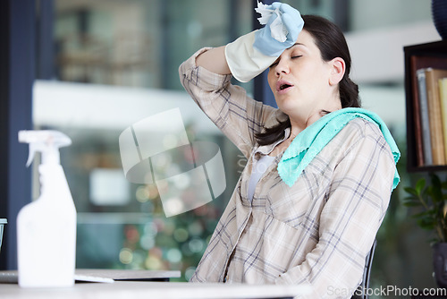 Image of Tired, stressed and frustrated cleaning lady resting after doing chores, hygiene and housework alone indoors. Exhausted and overworked domestic housewife wiping sweat with gloves on a break at home