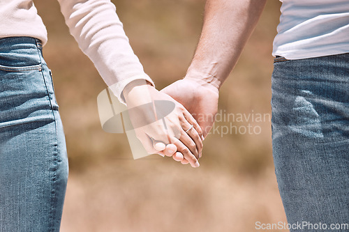 Image of Couple holding hands, love and care showing affection, friendship and romance while on a walk together in nature. Closeup of boyfriend and girlfriend expressing loving, caring and comforting emotion