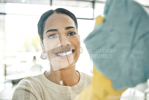 Image of Cleaning, chores and cleaner wiping windows with a soft cloth while wearing gloves in office. Smiling, young and female maid doing hygiene housekeeping. Beautiful lady keeping her home clean.