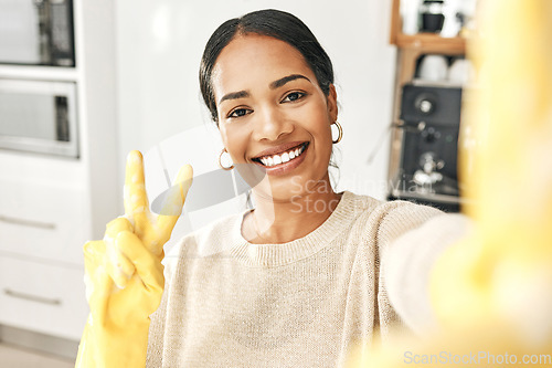 Image of Peace sign, clean and hygienic domestic taking a selfie with a hand gesture at home. Carefree woman enjoying good hygiene while cleaning, doing chores and housework alone expressing happiness.