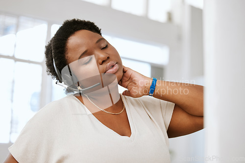 Image of Stressed, neck pain and tired call center agent stretching bad, strained or sore muscle while working with headset. Female ecommerce support consultant working overtime or sitting long hours at desk