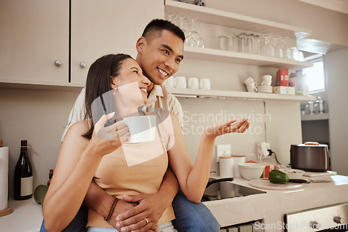 Image of Happy, loving and romantic couple bonding, standing and hugging at home in the kitchen. Husband and wife talking, affection and enjoying feeling carefree while having a cup of coffee in the morning