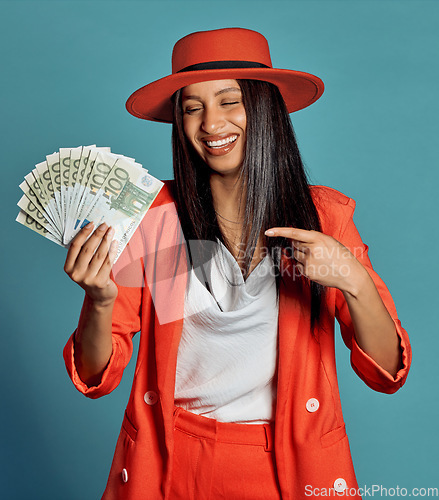 Image of Rich young woman holding cash, competition or lottery winnings pointing looking stylish, elegant and trendy. Happy, excited and celebrating female cheering with income, savings or investment returns