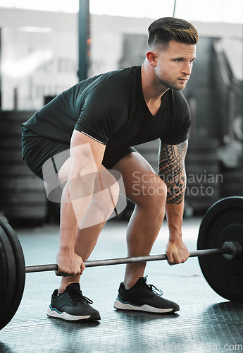 Image of Fit, active and strong man with barbell weight for lifting in gym workout, exercise and training. Serious, motivated and sporty athlete building muscle, cardio health and endurance in wellness centre