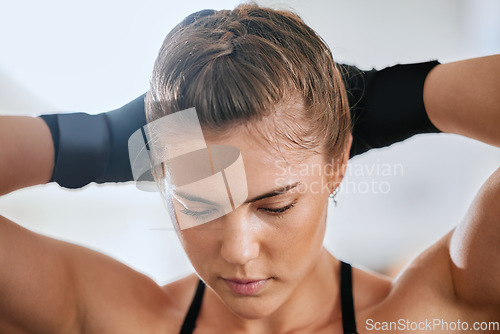 Image of Face of a young female boxer getting ready to train in the gym for a boxing match. Sporty, active and healthy athlete tying her hair to exercise. Motivated woman doing a fitness workout.