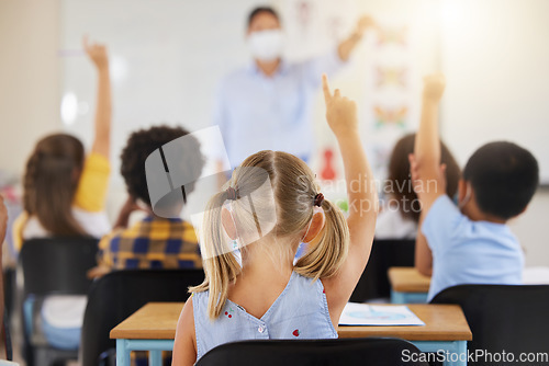 Image of School students raising hands to volunteer, participate and answer during lesson while learning in a classroom. Teacher asking questions to eager, smart and clever young kids questions for education