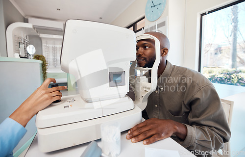 Image of Eye test, exam or screening with a young man at the optometrist using an automated refractor. Patient testing his vision and eyesight with an optician for prescription glasses or contact lenses