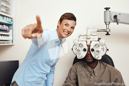 Image of Happy optometrist doing eye test on a patient, examining vision and doing optical exercise at an optometry checkup. Young black man consulting with an opthalmologist, measuring and checking eyesight