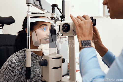 Image of Eye test, exam or screening with an ophthalmoscope and an optometrist or optician in the optometry industry. Young woman getting her eyes tested for prescription glasses or contact lenses for vision