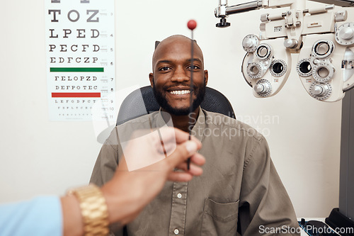 Image of Black man having his eyes tested at an optometrist. Smiling African American male consulting with an opthamologist, having a vision and eye care checkup. Guy testing for glaucoma or myopia