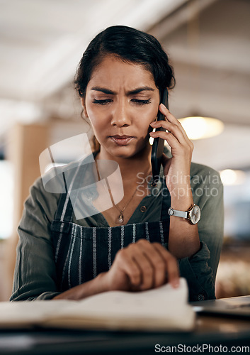 Image of Young and confused business owner on the phone making a stock order for her cafe, restaurant or coffee shop. A female employee, manager or store owner looking at a book of products or inventory.