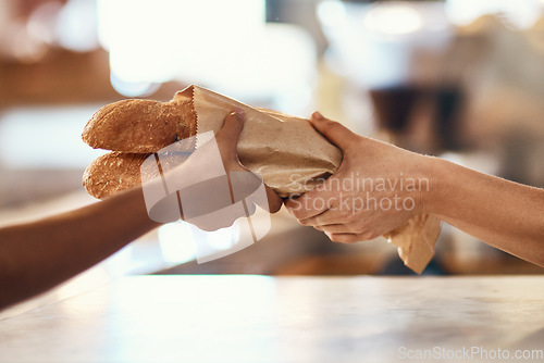 Image of Customer buying bread from bakery, purchasing baked goods and shopping for food at a shop. Hands of female client and employee giving service, taking product and helping with item at grocery store