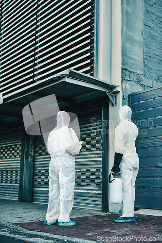 Image of Medical team and covid hygiene healthcare workers wearing hazmat suits for safety while at quarantine site outside. In protective gear for cleaning, disinfection and decontamination to fight virus