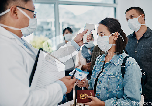 Image of Travel restriction, covid pandemic and temperature check at airport. Asian female wearing mask for corona virus prevention waiting in departure inspection line, doctor pointing digital thermometer.