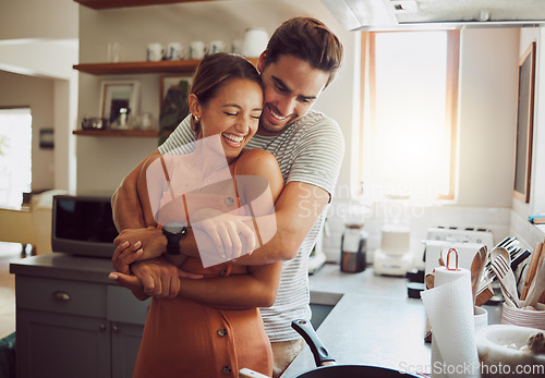 Image of Love, romance and fun couple hugging, cooking in a kitchen and sharing an intimate moment. Romantic boyfriend and girlfriend embracing, enjoying their relationship and being carefree together