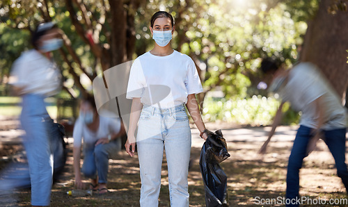 Image of Volunteers, hygiene and environmental team cleaning a park in covid masks together. Development, energy and recycling activists working in collaboration to put messy dirt in plastic bags and trash