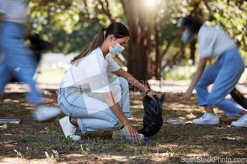 Image of Volunteer, recycle and reduce waste by picking up litter, dirt and garbage outdoors in a park during covid. A young team of female NGO activists cleaning the environment during the covid19 pandemic