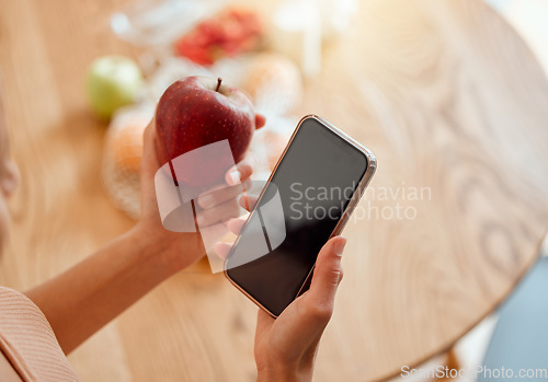 Image of Online, health and apple organic fruit of woman holding phone and looking at nutrition value. Young female browsing diet and wellness plan or recipes to make for a healthy meal and lifestyle.