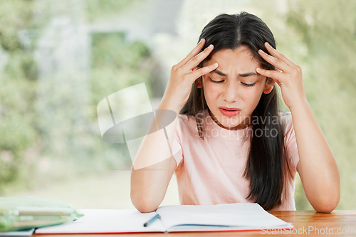 Image of Stress, anxiety and worry with a little girl struggling with her studies, education and learning at home. Confused, frustrated and upset student having trouble with homework and difficult study