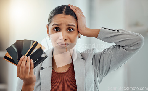 Image of Stressed, worried businesswoman in debt from shopping at work. Female in corporate finance, money issues headache, holds credit and debit cards. Frustration, economic inflation and expenses.