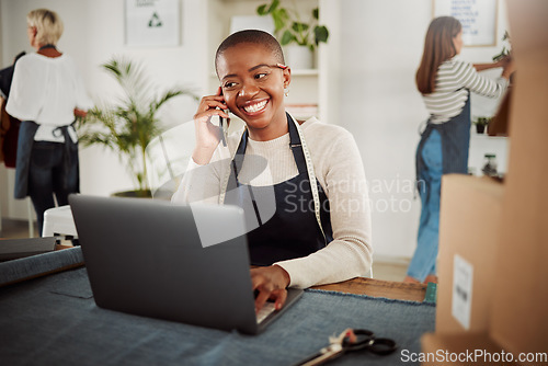 Image of . Designer talking on phone call, taking orders on laptop and working at a factory, fashion boutique or studio at work. Smiling and happy tailor, worker or stylist making conversation with supplier.