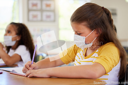 Image of School girls in classroom, covid education lockdown and social distance. Smart students creative drawing and writing at desks learning, wearing masks due to coronavirus disease regulations.