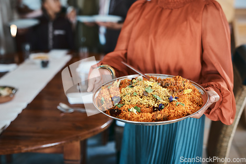 Image of Food, dinner and consumables with a traditional paella dish in the hands of a woman at home. Closeup of a bowl of spanish sea food, ready to serve and feed hungry family for lunch or healthy supper