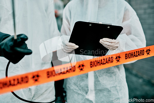 Image of Covid, pandemic and team doctors, scientists or healthcare workers wearing protective ppe to prevent virus spread at quarantine site. First responders wearing hazmat suit while standing behind tape