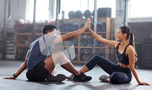 Image of Motivation, celebrate and support with fitness coach doing high five with woman in the gym. Active and fit woman training or practicing strength and stamina workout with her friend in a health center