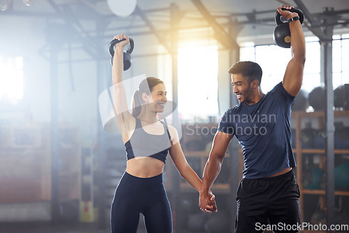 Image of Fitness, kettlebell and couple in a workout exercise and holding hands in a gym. Fit sports people in a relationship with a strong grip, exercising with weight equipment to build muscle together.