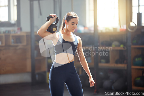 Image of Kettlebell training, exercise and gym fitness for strong, fit and active woman doing weight workout, sport and wellness challenge in a sports club. Healthy, toned and slim female athlete exercising