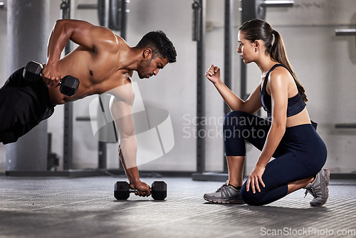 Image of Training, exercise and motivation with a fitness coach or personal trainer and her bodybuilder student during a workout in the gym. Health, sports and wellness with a heathy athlete exercising